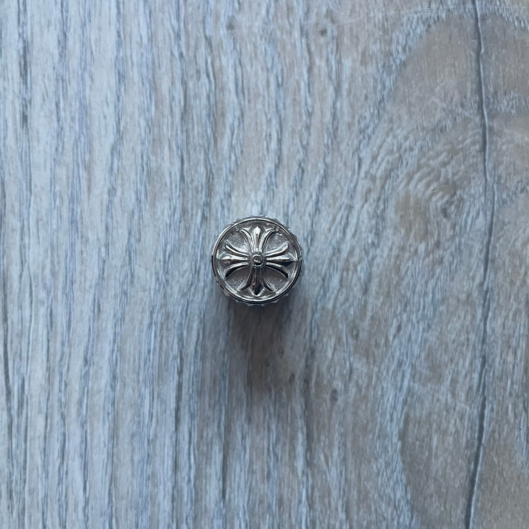 Chrome Hearts +22+ Roll-On Perfume features an aromatic oil blend with prominent jasmine and bergamot notes, designed as a concentrated roll-on fragrance. It is housed in a crystal bottle with a rhodium-plated sterling silver closure, hand crafted in France. The silver cap is detailed with raised Chrome Hearts crosses throughout, a larger cross on top, and embossed Chrome Hearts text wrapping around the base of the closure.