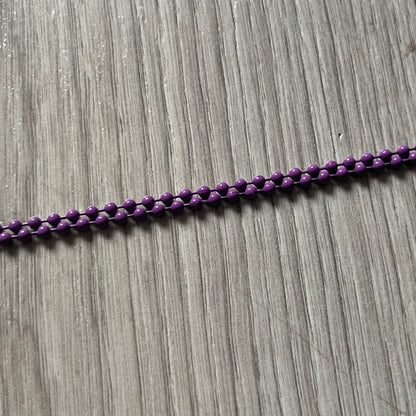 The Chrome Hearts 'Silichrome' Cross Purple Necklace showcases a silicone cross pendant with embossed CH lettering, twin cross graphics on the back, and a 2019 anniversary mark. Offered only through CH flagship stores, it comes paired with a purple ball chain and includes both the dustbag and paper receipt.