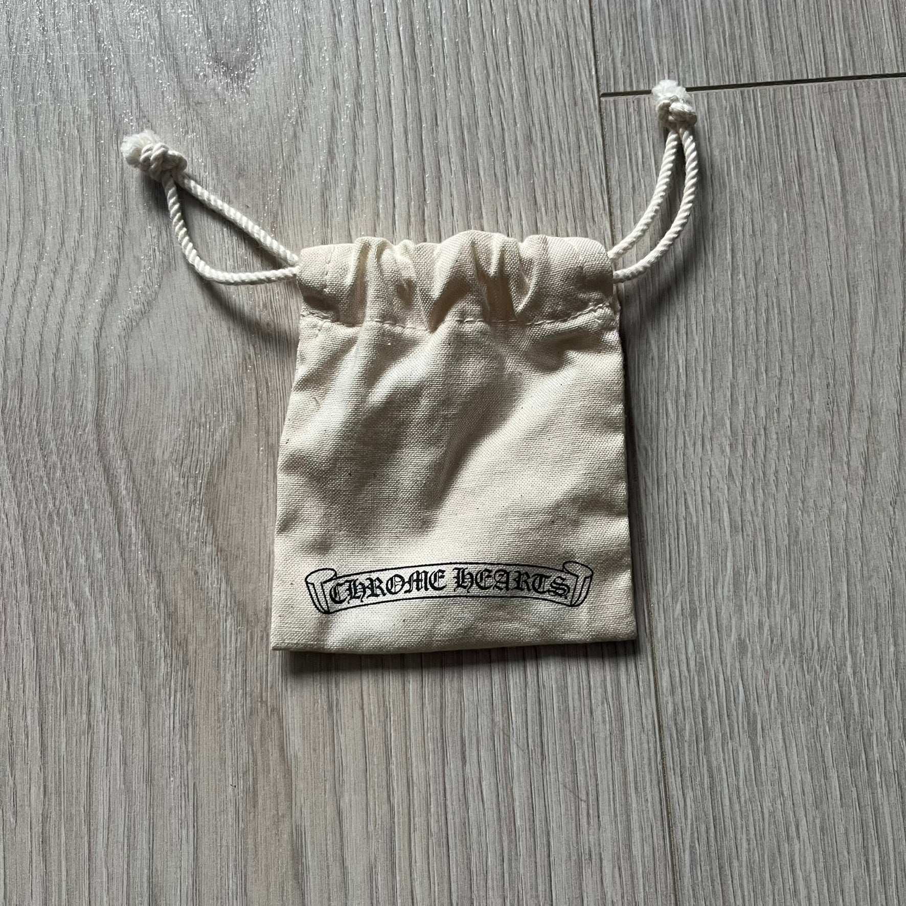 The Chrome Hearts 'Silichrome' Cross Purple Necklace showcases a silicone cross pendant with embossed CH lettering, twin cross graphics on the back, and a 2019 anniversary mark. Offered only through CH flagship stores, it comes paired with a purple ball chain and includes both the dustbag and paper receipt.