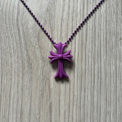 The Chrome Hearts 'Silichrome' Cross Purple Necklace showcases a silicone cross pendant with embossed CH lettering, twin cross graphics on the back, and a 2019 anniversary mark. Offered only through CH flagship stores, it comes paired with a purple ball chain and includes both the dustbag and paper receipt.