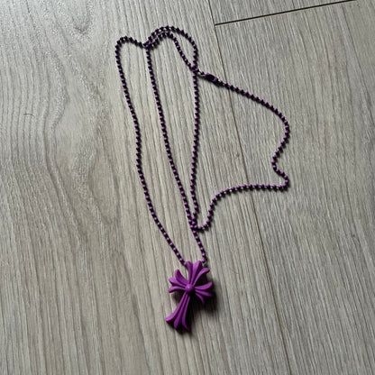 The Chrome Hearts 'Silichrome' Cross Purple Necklace showcases a silicone cross pendant with embossed CH lettering, twin cross graphics on the back, and a 2019 anniversary mark. Offered only through CH flagship stores, it comes paired with a purple ball chain and includes both the dustbag and paper receipt.