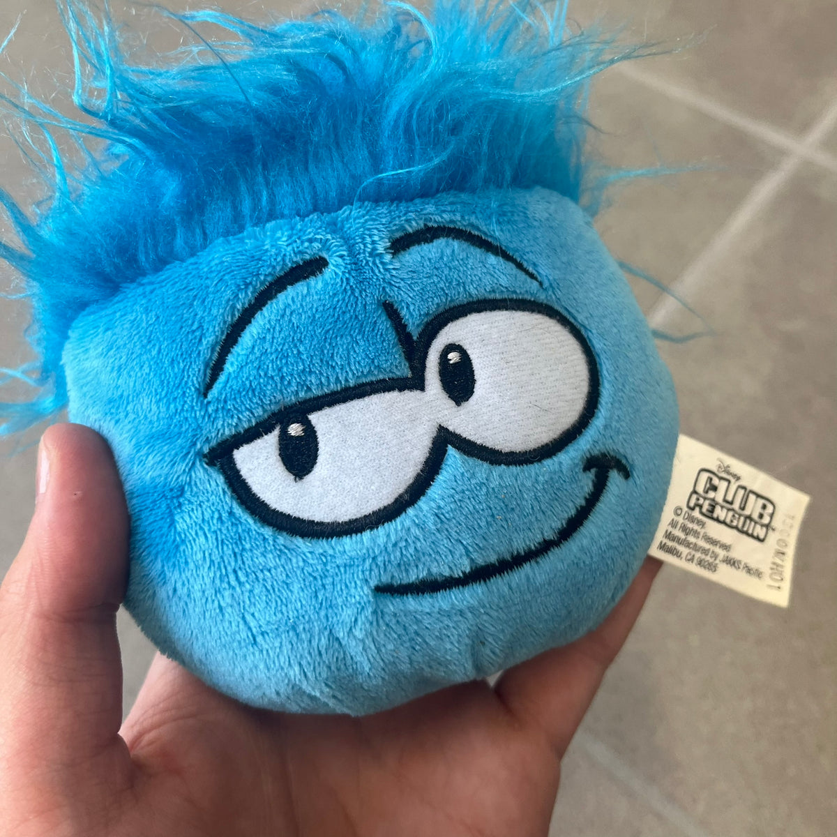 Club Penguin Series 2 Blue Puffle Plushie was Released in 2009 by Disney and Jakks Pacific, featuring a smirking embroidered face, troll-like hair and a half plush half beanie body. It comes with a Disney-licensed tag.