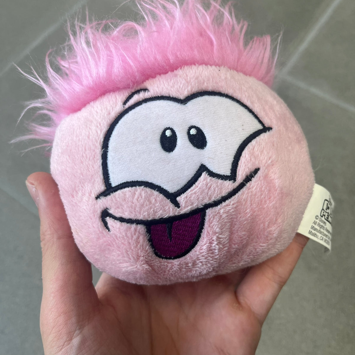 Club Penguin Series 2 Pink Puffle Plushie was Released in 2009 by Disney and Jakks Pacific, featuring an embroidered happy face with a tongue out, troll-like hair and a half plush half beanie body. It comes with a Disney-licensed tag.