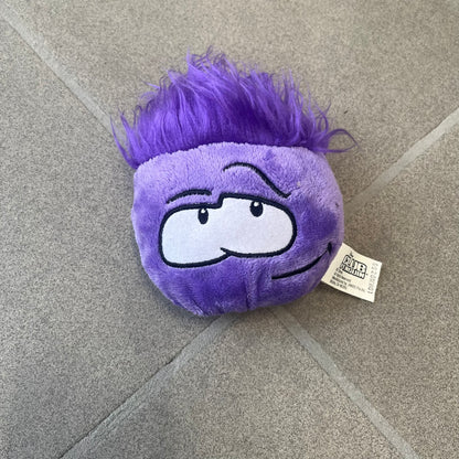 Club Penguin Series 2 Purple Puffle Plushie was Released in 2009 by Disney and Jakks Pacific, featuring a smirking looking up embroidered face, troll-like hair and a half plush half beanie body. It comes with a Disney-licensed tag.