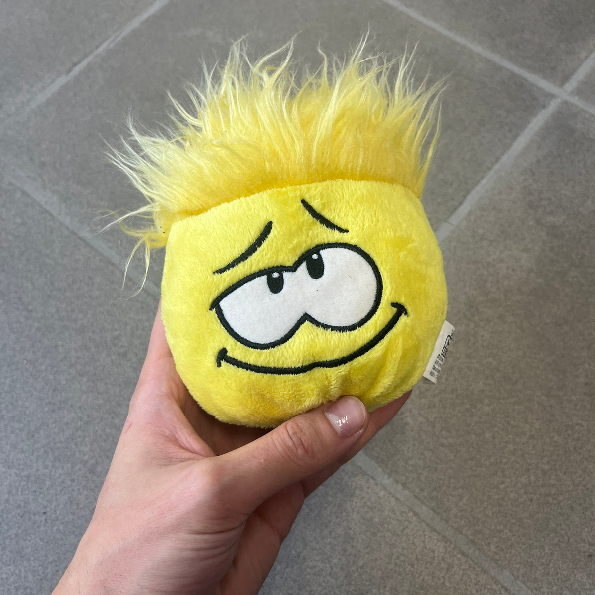 Club Penguin Series 2 Yellow Puffle Plushie was Released in 2009 by Disney and Jakks Pacific, featuring a looking up embroidered face, troll-like hair and a half plush half beanie body. It comes with a Disney-licensed tag.
