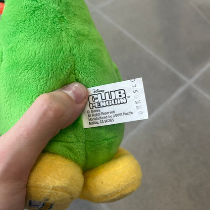 Club Penguin 2009 Series 3 Aunt Arctic Penguin Plushie is a green penguin with a pink beanie, freckles, black eyeglasses and a pencil next to the ear. Released in [year] by Disney and Jakks Pacific, featuring an embroidered Club Penguin logo on the bottom of the foot. It comes with a Disney-licensed tag.