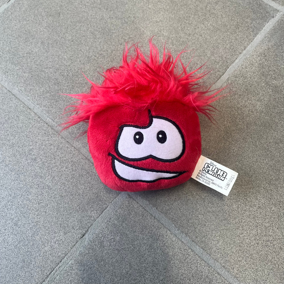 Club Penguin Series 4 Red Puffle Plushie was Released in 2009 by Disney and Jakks Pacific, featuring a smilling embroidered face, troll-like hair and a half plush half beanie body. It comes with a Disney-licensed tag.
