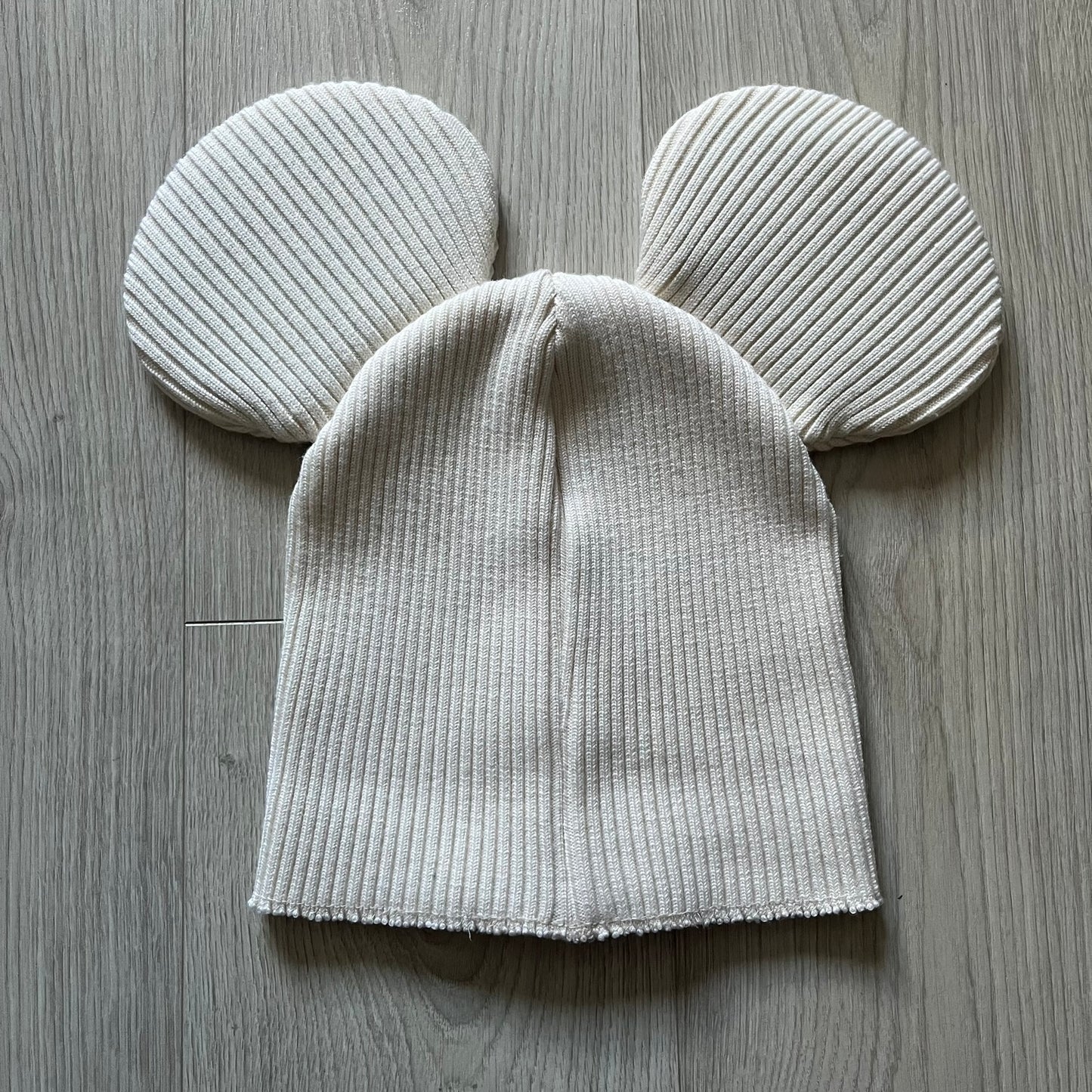 Released in Autumn/Winter 2018, this Comme des Garçons beanie playfully reimagines the classic knit hat with ‘Mickey Mouse’-inspired ears. Crafted in an off-white shade with ribbed detailing, it balances fun design with signature CDG avant-garde flair. A standout seasonal accessory with a collectible edge.