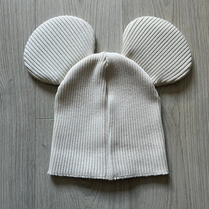 Released in Autumn/Winter 2018, this Comme des Garçons beanie playfully reimagines the classic knit hat with ‘Mickey Mouse’-inspired ears. Crafted in an off-white shade with ribbed detailing, it balances fun design with signature CDG avant-garde flair. A standout seasonal accessory with a collectible edge.