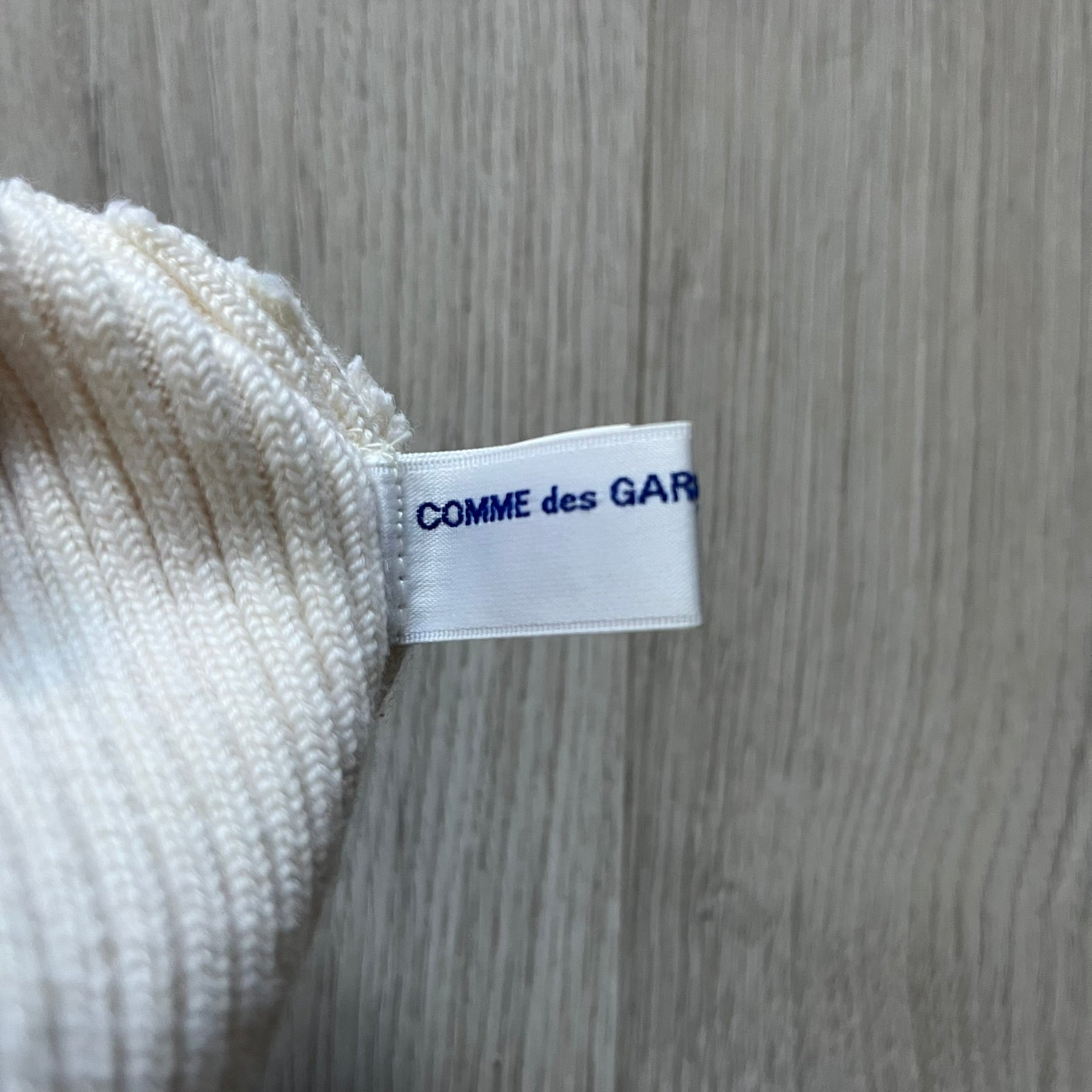 Released in Autumn/Winter 2018, this Comme des Garçons beanie playfully reimagines the classic knit hat with ‘Mickey Mouse’-inspired ears. Crafted in an off-white shade with ribbed detailing, it balances fun design with signature CDG avant-garde flair. A standout seasonal accessory with a collectible edge.