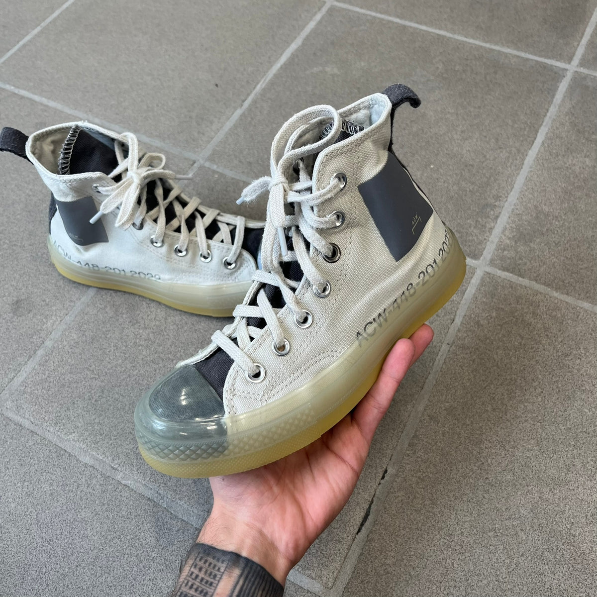 Converse x A-COLD-WALL* Silver Birch Chuck 70 (A02276C) is a limited-edition high-top sneaker from the collaboration with British designer Samuel Ross, released October 6, 2022 in a Silver Birch/Pavement colorway. The canvas upper features a rubber toe cap and a Converse heel plate, with a distinctive translucent, marbled speckled sole.