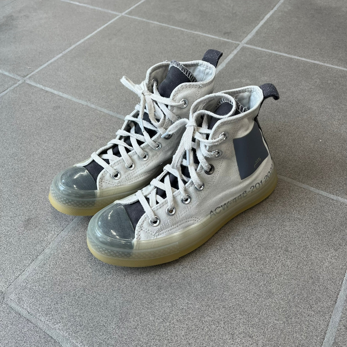 Converse x A-COLD-WALL* Silver Birch Chuck 70 (A02276C) is a limited-edition high-top sneaker from the collaboration with British designer Samuel Ross, released October 6, 2022 in a Silver Birch/Pavement colorway. The canvas upper features a rubber toe cap and a Converse heel plate, with a distinctive translucent, marbled speckled sole.