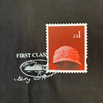 Corteiz x Skepta Konnichiwa 10th Anniversary BlackTee is a 100% cotton T-shirt released to mark the 10th anniversary of Skepta's "Konnichiwa" album, featuring the original album cover artwork with a red postage stamp graphic of Skepta. The design includes a "First Class" ink stamp alongside the Corteiz logo replacing the original cover's "London" mark.