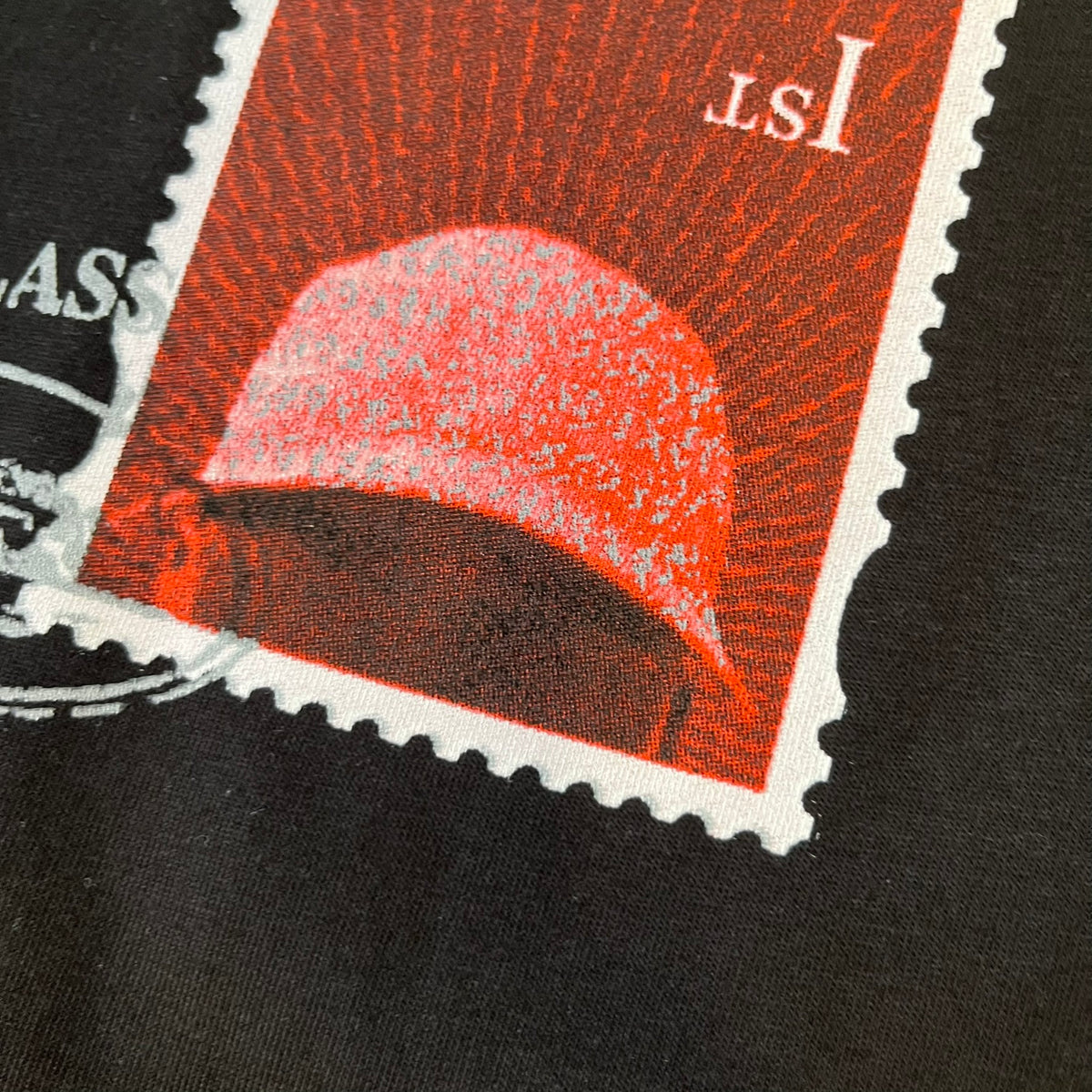 Corteiz x Skepta Konnichiwa 10th Anniversary BlackTee is a 100% cotton T-shirt released to mark the 10th anniversary of Skepta's "Konnichiwa" album, featuring the original album cover artwork with a red postage stamp graphic of Skepta. The design includes a "First Class" ink stamp alongside the Corteiz logo replacing the original cover's "London" mark.