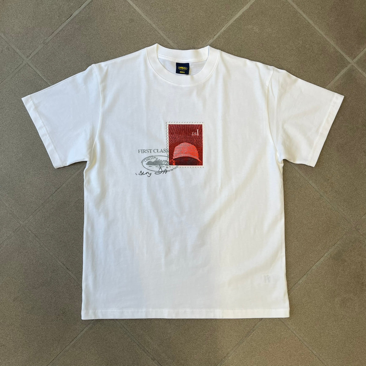 Corteiz x Skepta Konnichiwa 10th Anniversary White Tee is a 100% cotton T-shirt released to mark the 10th anniversary of Skepta's "Konnichiwa" album, featuring the original album cover artwork with a red postage stamp graphic of Skepta. The design includes a "First Class" ink stamp alongside the Corteiz logo replacing the original cover's "London" mark.