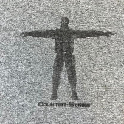 Counter Strike 2000's Bootleg Gray Tee is a gray, 100% cotton European bootleg made in Greece on an "Apple T-Shirt" blank, featuring a CS 1.6 counter-terrorist model T-posing on the front with "Counter-Strike" text printed below.