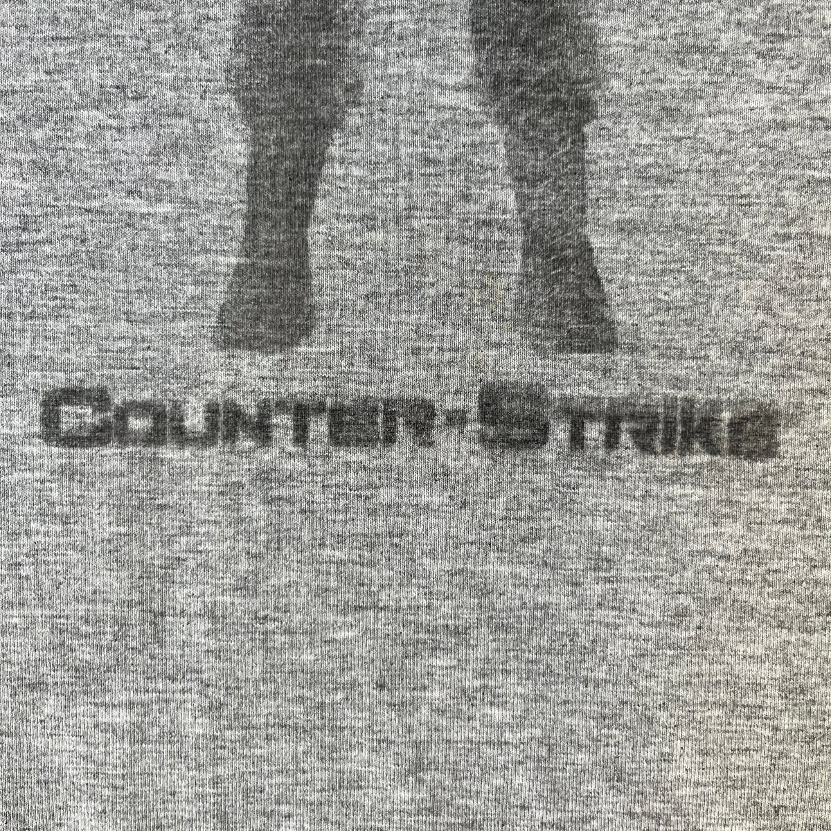 Counter Strike 2000's Bootleg Gray Tee is a gray, 100% cotton European bootleg made in Greece on an "Apple T-Shirt" blank, featuring a CS 1.6 counter-terrorist model T-posing on the front with "Counter-Strike" text printed below.