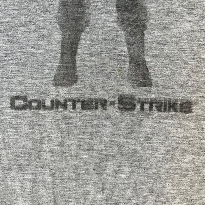 Counter Strike 2000's Bootleg Gray Tee is a gray, 100% cotton European bootleg made in Greece on an "Apple T-Shirt" blank, featuring a CS 1.6 counter-terrorist model T-posing on the front with "Counter-Strike" text printed below.