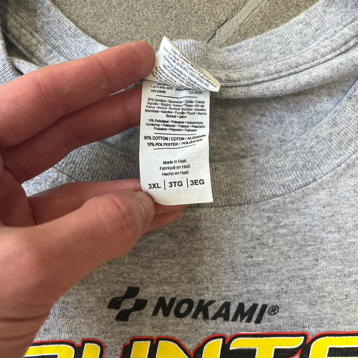 Counter Strike 2015 Arcade Block Gray Tee is a gray T-shirt featuring two Counter-Terrorists in yellow tones on a red background, with a yellow Counter-Strike text logo and a Nokami logo above the graphic. Two “Notindendo” logos sit on either side of the artwork. The shirt was available in the 2015 Arcade Block, specifically in the Nerd Block.