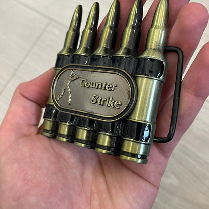 Counter Strike Metal Belt Buckle featuring five metal bullets with black vitreous enamel stripes. Includes a metal dog tag plaque on the front with “Counter Strike” text and the iconic Counter Strike logo of a shooter.