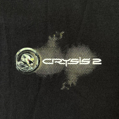 Crysis 2 Promo 2011 Black Tee features a black design with a small Crysis 2 logo on the front right chest printed over a mesh-style graphic inspired by the game. The back features a large graphic of a Force Recon Marine holding a weapon, combined with additional futuristic mesh details from the Crysis universe. Made on a Fruit of the Loom blank.
