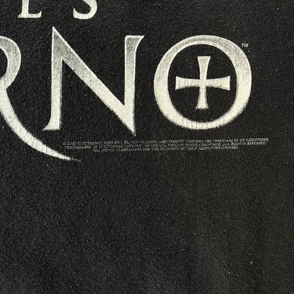 Dante's Inferno 2010 Black Promo Tee features a black construction made on an Anvil blank. The front has the Dante's Inferno game logo with a cross graphic on the left, featuring a red fabric-like detail, with small white licensing text underneath.
