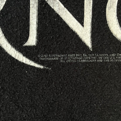 Dante's Inferno 2010 Black Promo Tee features a black construction made on an Anvil blank. The front has the Dante's Inferno game logo with a cross graphic on the left, featuring a red fabric-like detail, with small white licensing text underneath.
