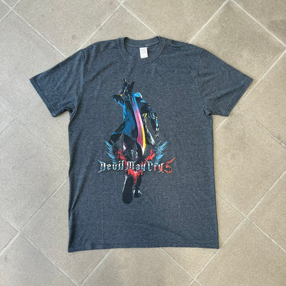 Devil May Cry 5 Promo 2019 Gray Tee is made on a Gildan blank in grey cotton. The front features the Devil May Cry 5 game cover but only with Nero holding his sword, along with large “Devil May Cry 5” text. Made as a promotional T-shirt for the game.