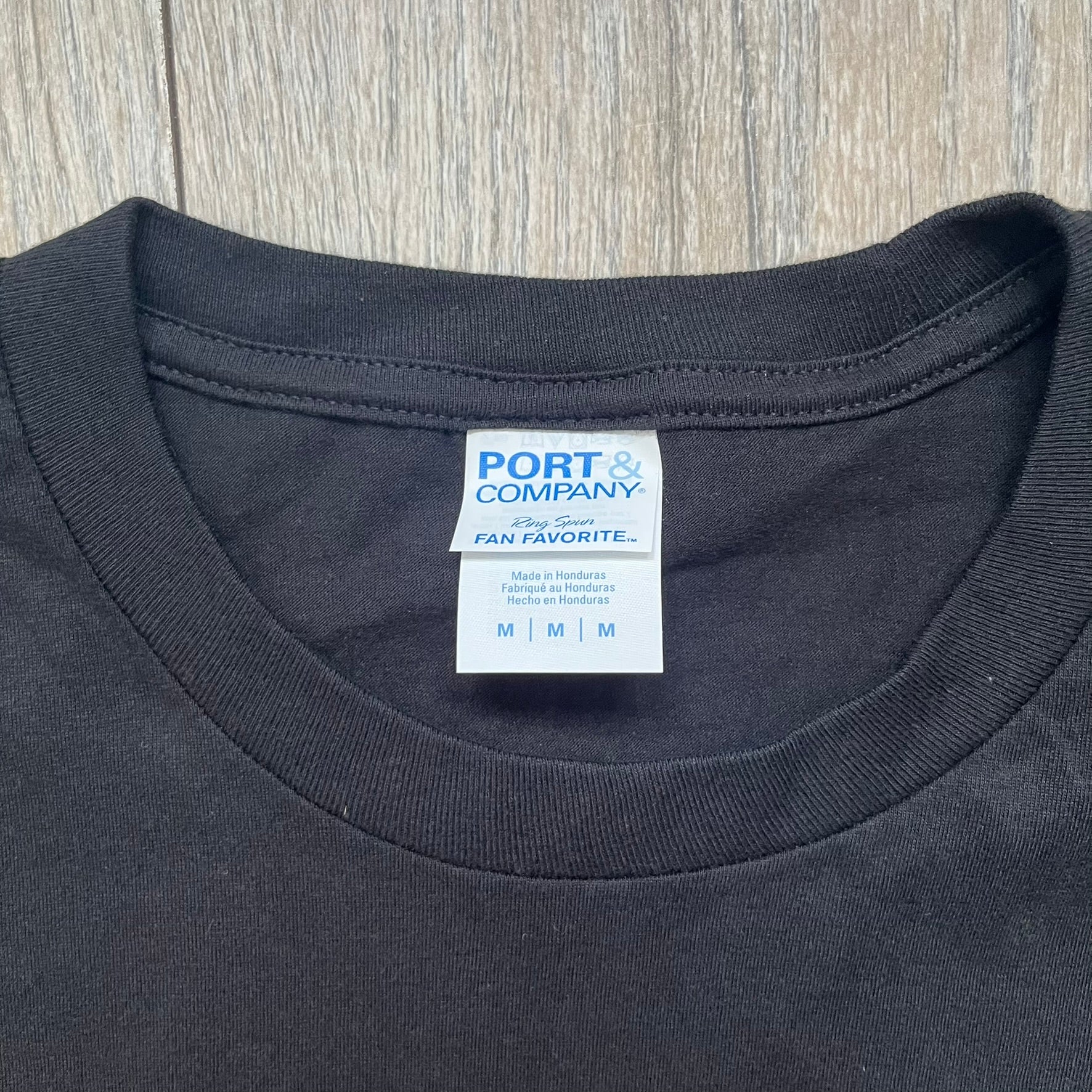 Dexter “Blood Never Lies” 2017 Tee is a black T-shirt featuring a front graphic with red blood-style “Dexter” and “Blood Never Lies” text. Between the texts, the print shows blood-covered tools with Dexter visible in the reflection of a saw. Small 2017 Showtime licensing text appears beneath the graphic, confirming official series merchandise.