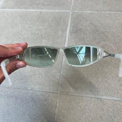 Diesel 2000's Clear Jumbo Sunglasses feature thin silver-tone wire temples with clear plastic sections extending over the ends and front of the frame. The lenses have a grey-tinted transparent finish, with visible screws on the front. A small silver Diesel logo is placed on the side, with white Diesel text printed in the corner of one lens.
