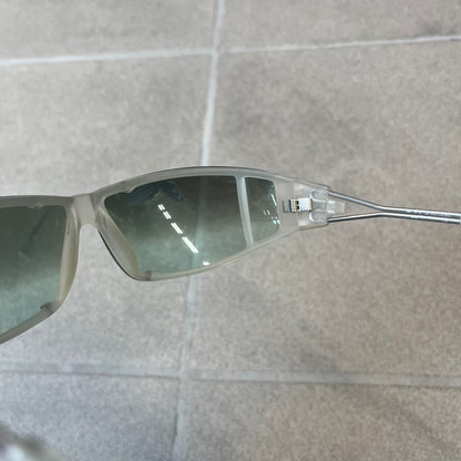 Diesel 2000's Clear Jumbo Sunglasses feature thin silver-tone wire temples with clear plastic sections extending over the ends and front of the frame. The lenses have a grey-tinted transparent finish, with visible screws on the front. A small silver Diesel logo is placed on the side, with white Diesel text printed in the corner of one lens.
