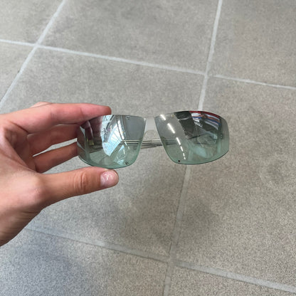 Diesel 2000's Clear Jumbo Sunglasses feature thin silver-tone wire temples with clear plastic sections extending over the ends and front of the frame. The lenses have a grey-tinted transparent finish, with visible screws on the front. A small silver Diesel logo is placed on the side, with white Diesel text printed in the corner of one lens.
