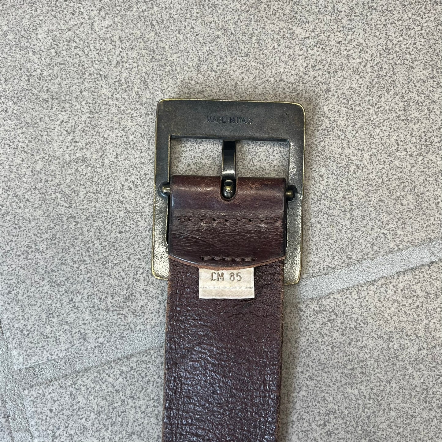 Diesel 2000's Only The Brave Brown Leather Belt features a brown 100% cow leather construction with a bronze-tone buckle. The buckle has engraved Diesel branding, including “Only The Brave Since 1978” text and other details. The belt is marked “Extra Tough,” with gold Diesel text printed on the inside. Made in Italy.
