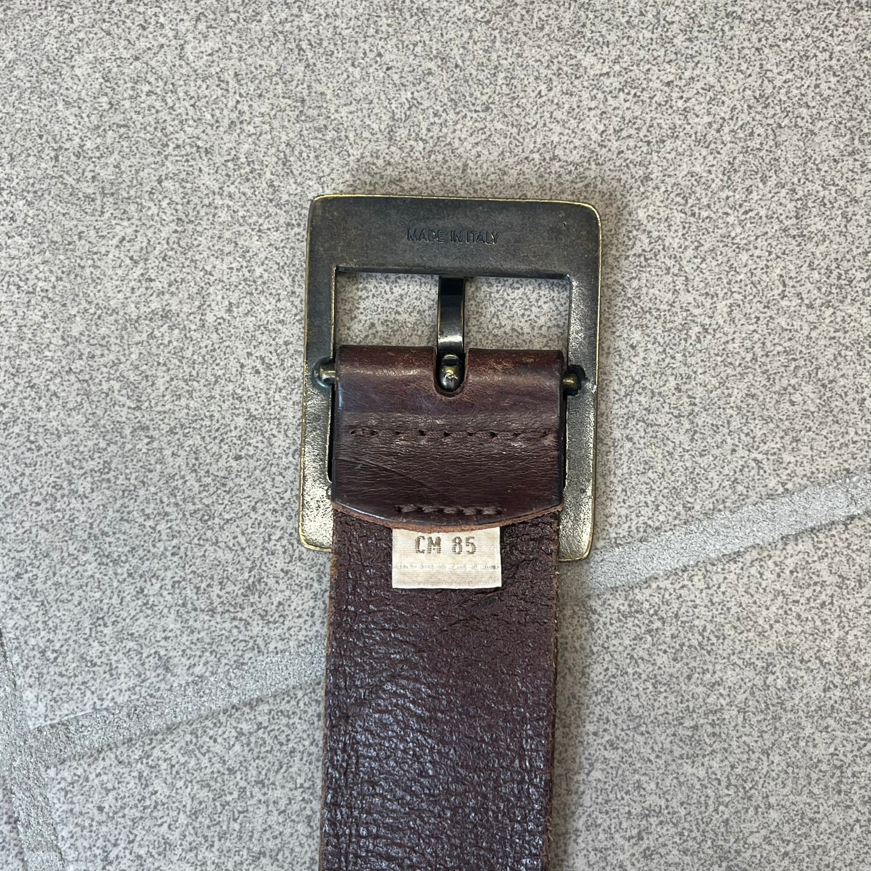 Diesel 2000's Only The Brave Brown Leather Belt features a brown 100% cow leather construction with a bronze-tone buckle. The buckle has engraved Diesel branding, including “Only The Brave Since 1978” text and other details. The belt is marked “Extra Tough,” with gold Diesel text printed on the inside. Made in Italy.

