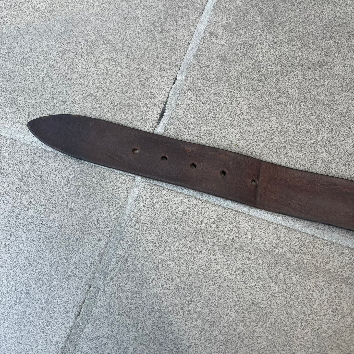 Diesel 2000's Only The Brave Brown Leather Belt features a brown 100% cow leather construction with a bronze-tone buckle. The buckle has engraved Diesel branding, including “Only The Brave Since 1978” text and other details. The belt is marked “Extra Tough,” with gold Diesel text printed on the inside. Made in Italy.
