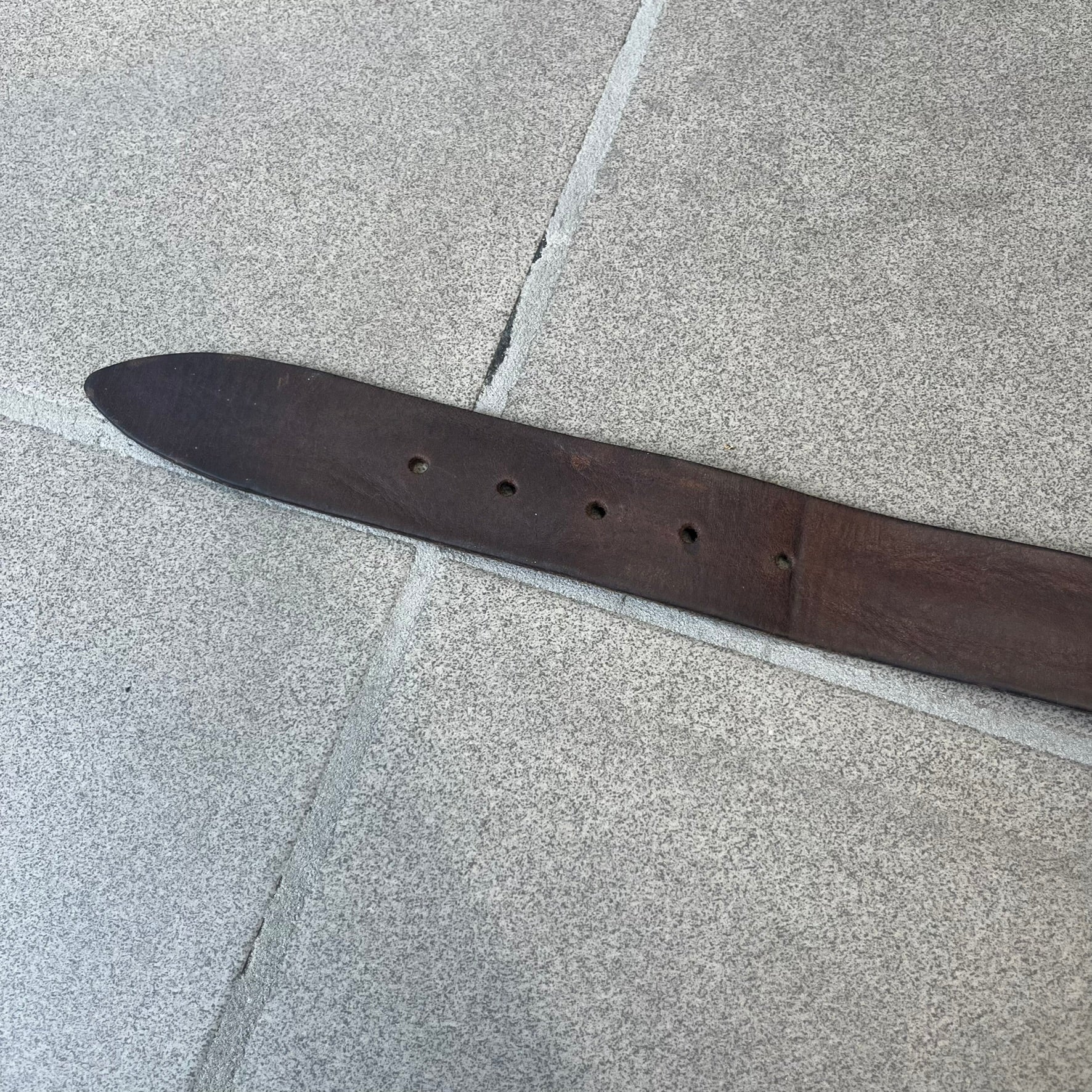 Diesel 2000's Only The Brave Brown Leather Belt features a brown 100% cow leather construction with a bronze-tone buckle. The buckle has engraved Diesel branding, including “Only The Brave Since 1978” text and other details. The belt is marked “Extra Tough,” with gold Diesel text printed on the inside. Made in Italy.
