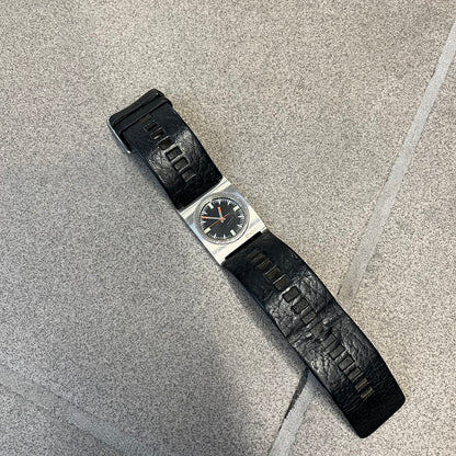 Diesel 2000’s Square DZ2107 Analog Watch has a square stainless steel case with an engraved Diesel logo in the bottom right corner. The circular black dial has orange hands, and the watch is fitted with a black leather strap.