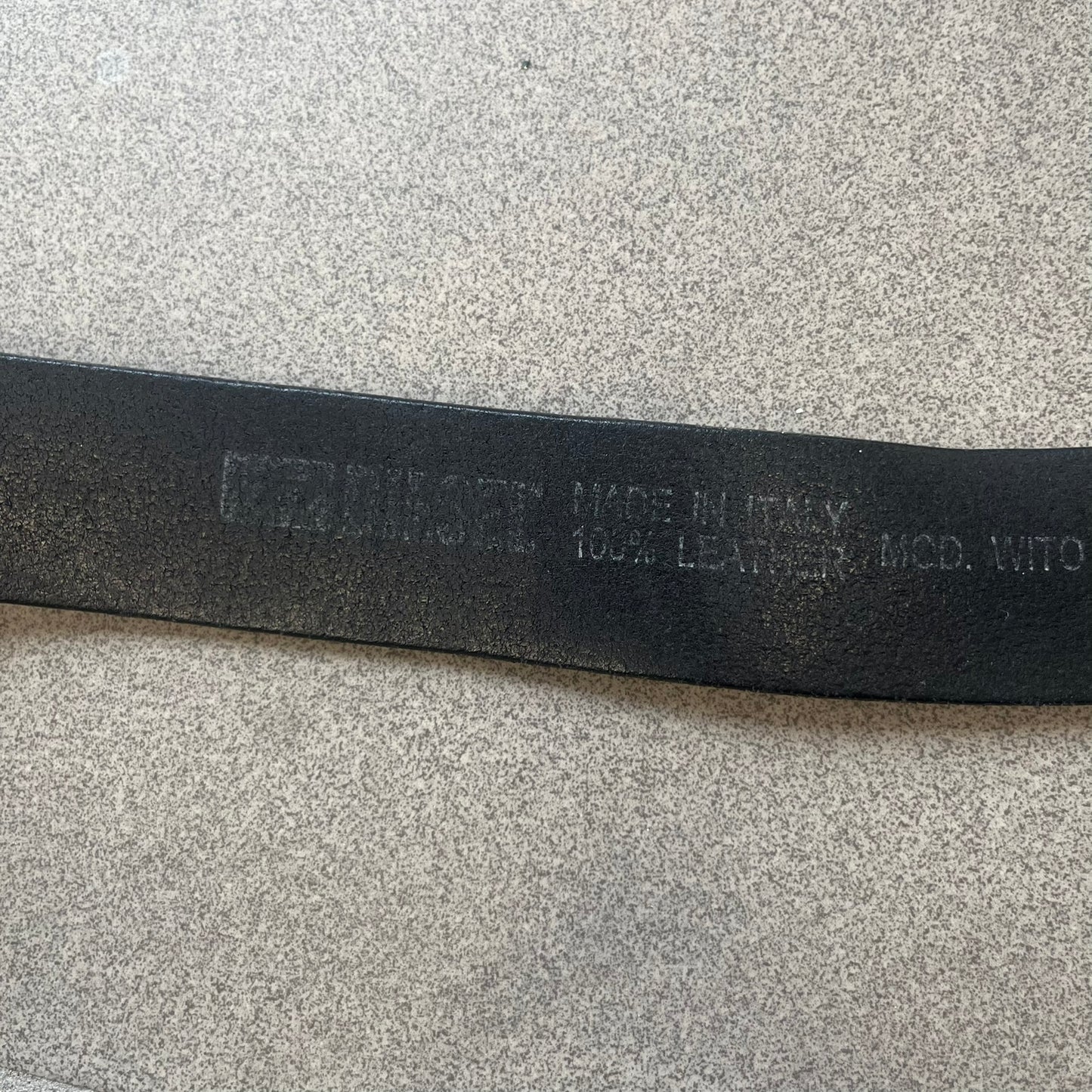 Diesel 2000s Vintage Buckle Leather Belt features a black leather strap made in Italy. The belt has a large rectangular metal buckle designed to look like a worn metal sheet, with a Diesel logo formed from small perforated holes. The buckle includes visible screws on the sides and the belt is made from 100% leather.
