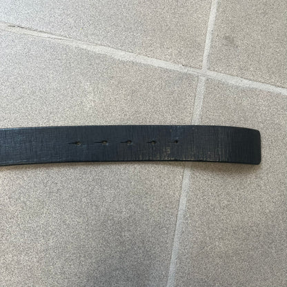 Diesel 2000s Vintage Buckle Leather Belt features a black leather strap made in Italy. The belt has a large rectangular metal buckle designed to look like a worn metal sheet, with a Diesel logo formed from small perforated holes. The buckle includes visible screws on the sides and the belt is made from 100% leather.

