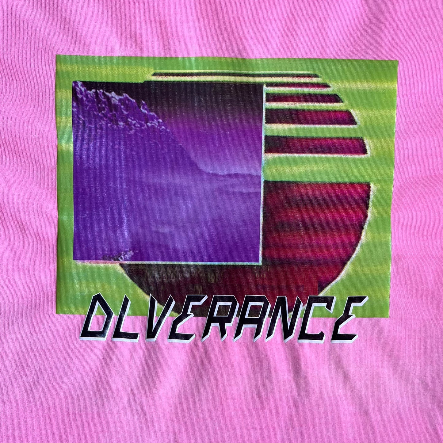 Diesel DLVERANCE Bright Pink Tee features a 100% cotton jersey construction with a fluorescent pink pigment-dyed finish. The front has a rubberised “DLVERANCE” graphic, with a small rubber “Copyright” logo on the lower back.