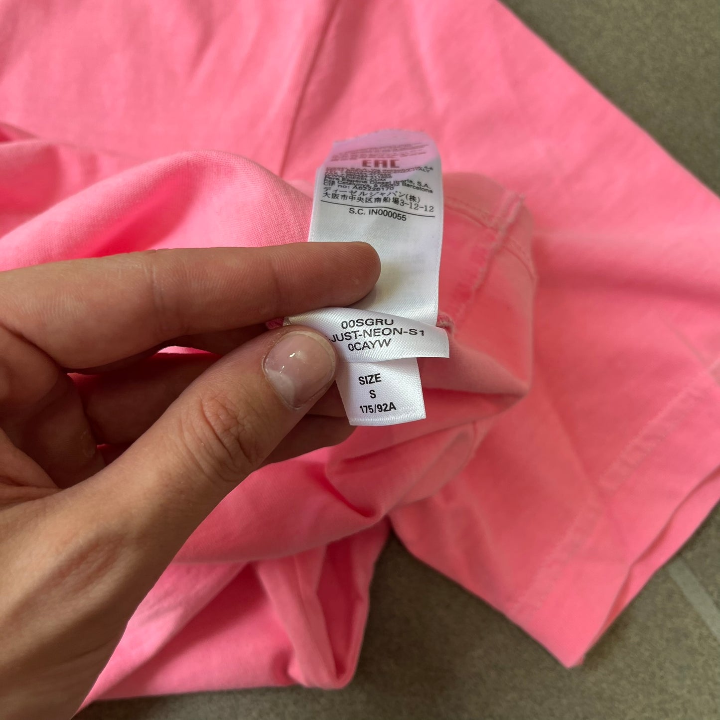 Diesel DLVERANCE Bright Pink Tee features a 100% cotton jersey construction with a fluorescent pink pigment-dyed finish. The front has a rubberised “DLVERANCE” graphic, with a small rubber “Copyright” logo on the lower back.