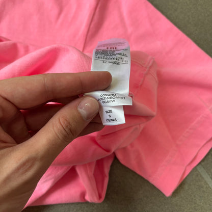 Diesel DLVERANCE Bright Pink Tee features a 100% cotton jersey construction with a fluorescent pink pigment-dyed finish. The front has a rubberised “DLVERANCE” graphic, with a small rubber “Copyright” logo on the lower back.