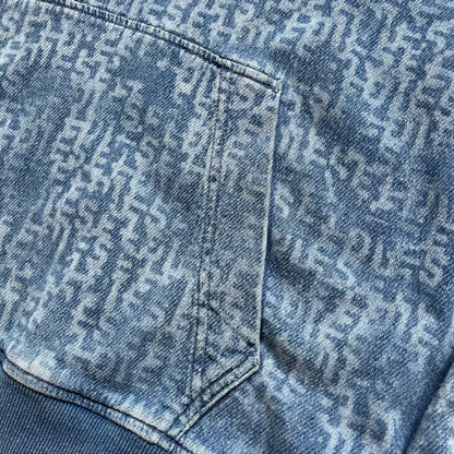 Diesel “Denim” Logo Blue Hoodie is a blue hooded sweatshirt designed with a denim-inspired colorway and washed effect throughout. The fabric features varying light and dark blue shades to mimic the appearance of worn denim, along with an all-over Diesel text pattern in a slightly lighter tone. A small red Diesel patch is placed on the chest, while the cuffs and hem are finished in a contrasting navy color.&nbsp;