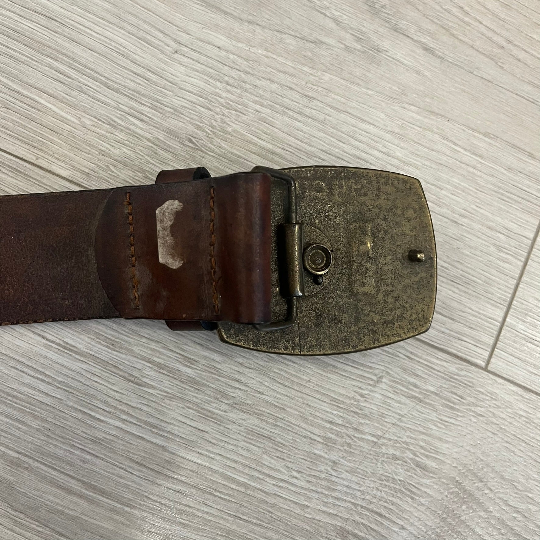 Diesel “Only The Brave” leather belt crafted in Italy from 100% brown leather and finished with a metal buckle with leather front. The buckle displays the Mohawk Warrior helmet motif with surrounding Diesel branding for an iconic look.