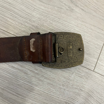 Diesel “Only The Brave” leather belt crafted in Italy from 100% brown leather and finished with a metal buckle with leather front. The buckle displays the Mohawk Warrior helmet motif with surrounding Diesel branding for an iconic look.