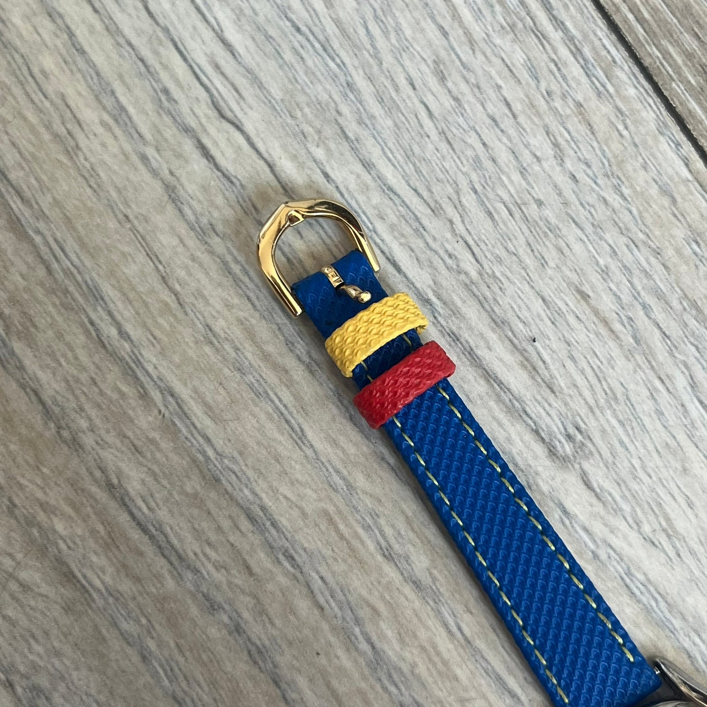 Disney Winnie-the-Pooh 1990s Analog Watch features blue leather straps, a gold-tone case, and a navy dial. The dial displays gold hour markers with Winnie the Pooh illustrated in the center. The case back is marked with official Disney licensing and indicates it was made exclusively for Disney. This watch is sized for smaller wrists.
