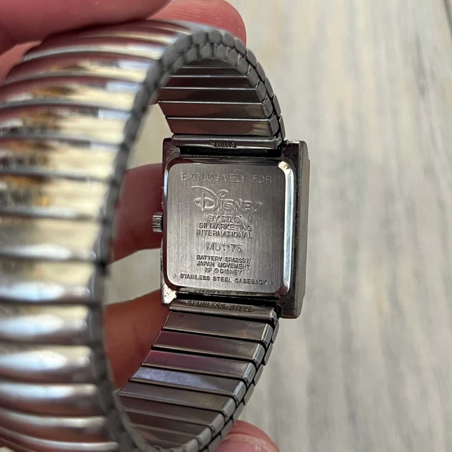 Disney Winnie-the-Pooh Eeyore 1990's Analog Watch is a stainless steel watch with a shiny finish and a stretch expansion bracelet made from connected metal links. The dial features silver numerals with a graphic of Eeyore. The caseback includes "Exclusively for Disney". Bracelet is for smaller wrists.
