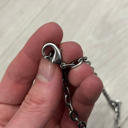 Dolce &amp; Gabbana Propaganda Dog Tag Necklace, featuring a silver stainless steel square tag with four visible screws and the D&amp;G logo engraved on the front. The tag hangs from a durable cable chain, combining sturdy construction with clean, industrial-inspired detailing.