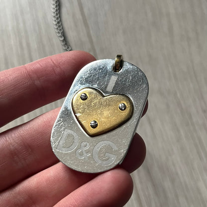 Dolce & Gabbana "I ❤️ D&G" Gold Dog Tag Necklace with a silver stainless steel ball chain, featuring a dog tag engraved with a light "I", a gold metal heart with 3 visible screws, and "D&G" text below, forming the "I ❤️ D&G" design. A playful and collectible vintage piece.