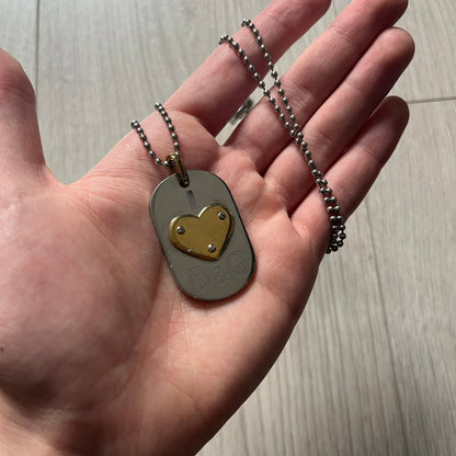 Dolce &amp; Gabbana "I ❤️ D&G" Gold Dog Tag Necklace with a silver stainless steel ball chain, featuring a dog tag engraved with a light "I", a gold metal heart with 3 visible screws, and "D&G" text below, forming the "I ❤️ D&G" design. A playful and collectible vintage piece.